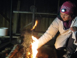 Sofia making a birch fire to smoke reindeer meat